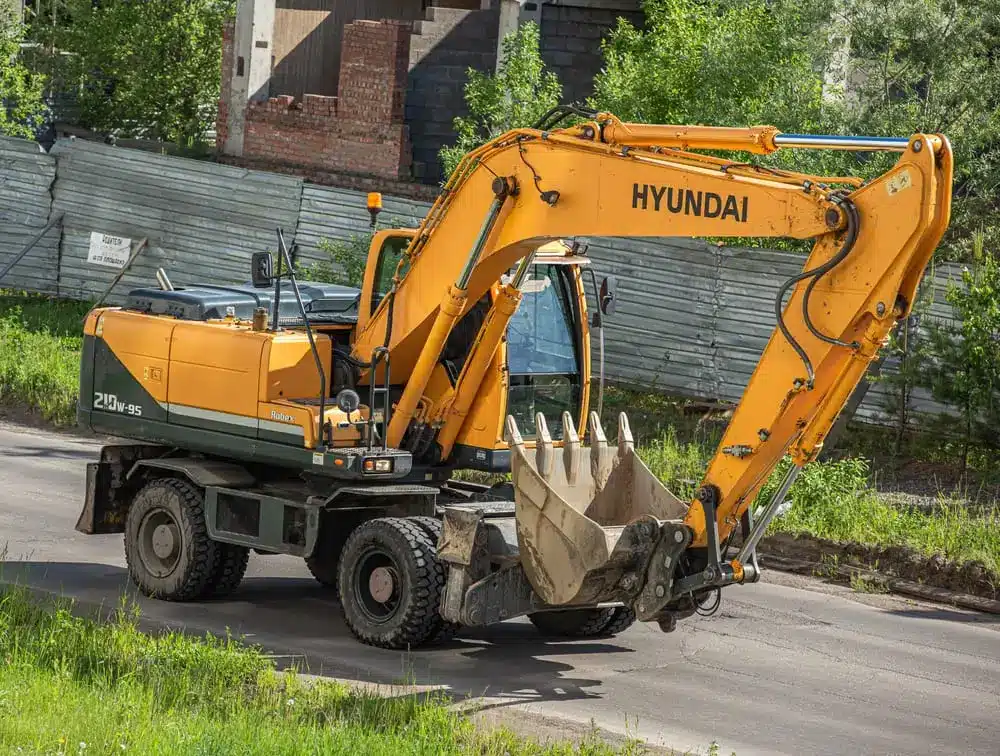 Une pelleteuse Hyundai circule sur la route.