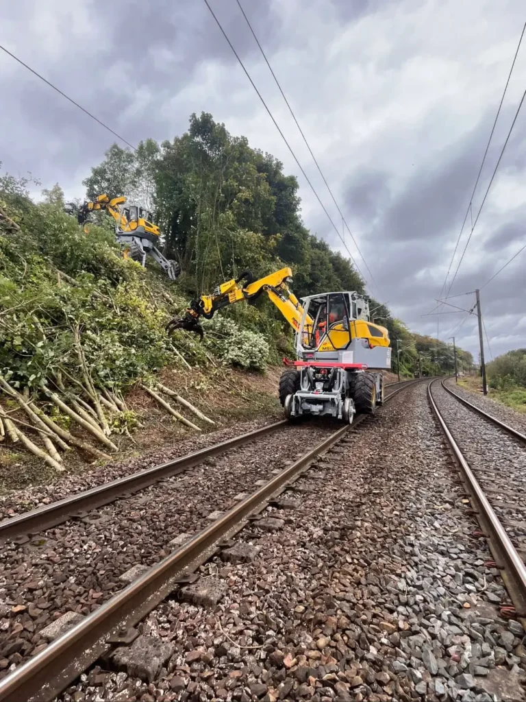 Une machine jaune et noire est posée sur les rails.