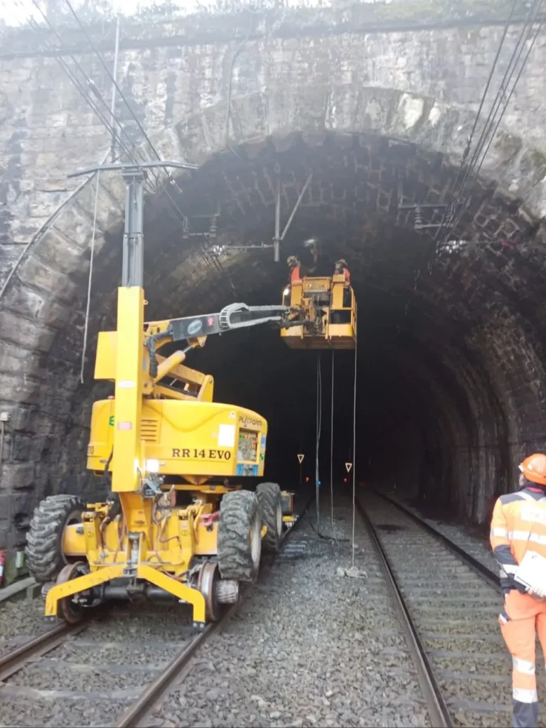 Une machine jaune et noire est posée sur les rails.