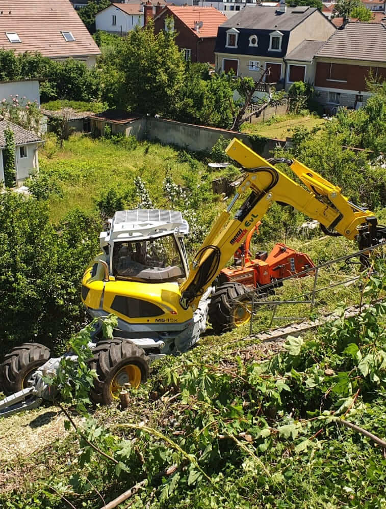 Un véhicule de construction jaune et noir travaille sur une colline.