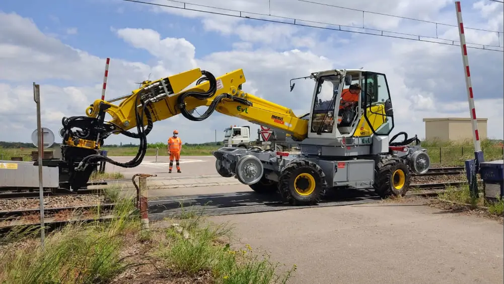 Une machine de construction travaille sur une voie ferrée.