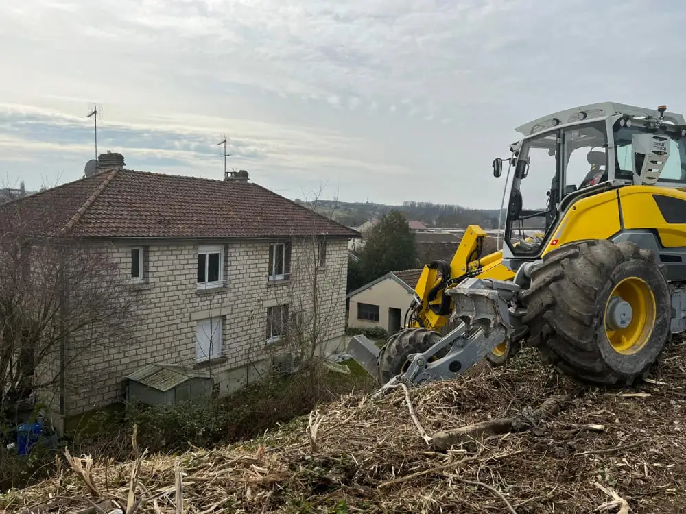 Un tracteur jaune et noir est garé sur une colline verdoyante.