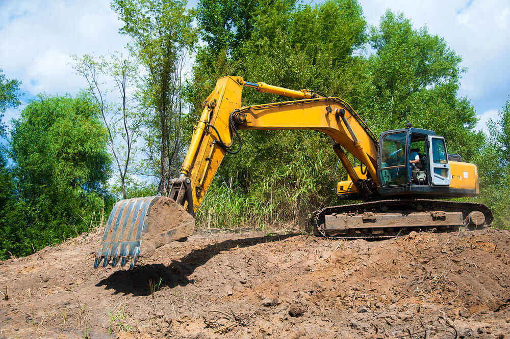 Une excavatrice en train de déterrer sur un chantier de construction.